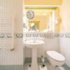 Schönes Badezimmer mit Waschbecken, Toilette und Handtuchwärmer