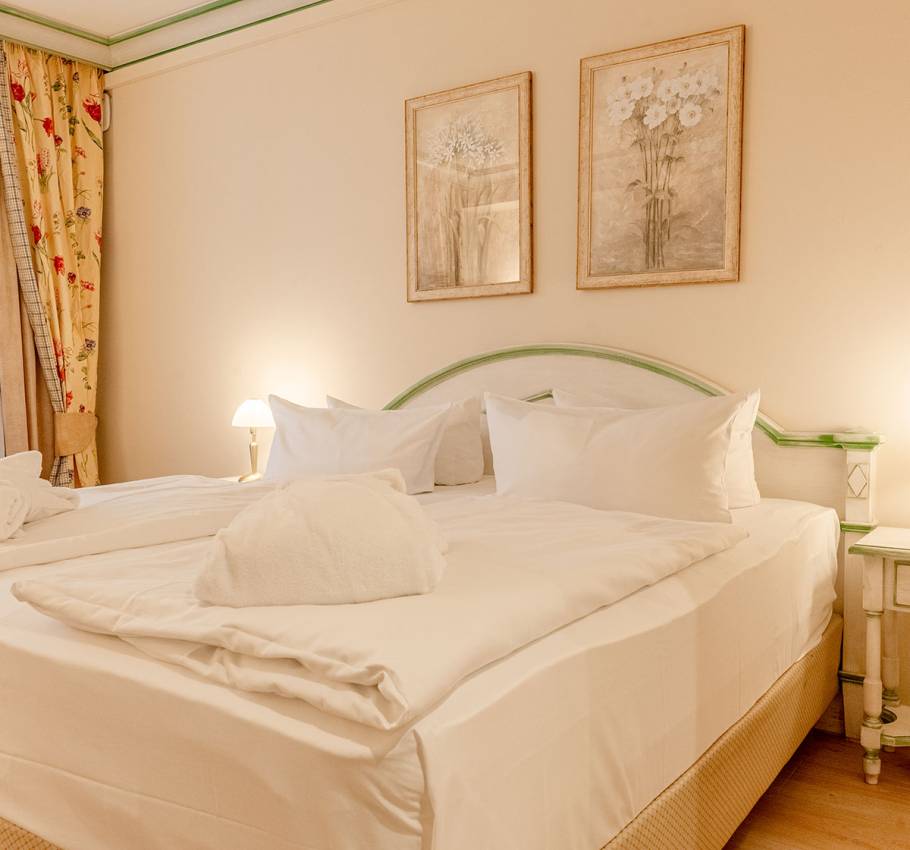 Doppelzimmer im Rugard Strandhotel auf Rügen mit Blick auf das große Bett, dekorierte Wände und weiche Bettwäsche.