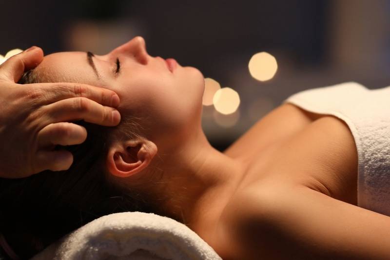 Nahaufnahme einer Frau, die eine entspannende ayurvedische Kopfmassage erhält.