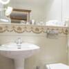 Waschbecken und Toilette in einem Hotel Badezimmer, darüber ein Spiegel