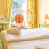 Nahaufnahme eines Hotelbettes, darauf ein gefalteter Bademantel, im Hintergrund ein Fenster