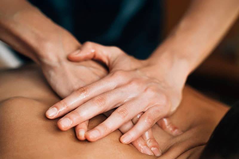 Ayurvedische Druckmassage mit Öl im Nackenbereich.