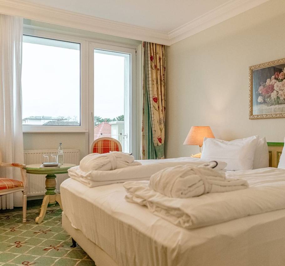 Doppelzimmer im Rugard Strandhotel Binz mit Balkon, gemütlichem Bett und klassischer Einrichtung