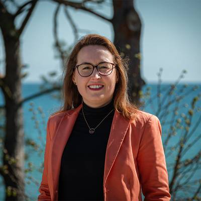 Potraitbild der Direktionsassistentin Dorothee Schicht vor der Ostsee, die bei Presse- und Kooperationsfragen der Arkona Hotels hilft.