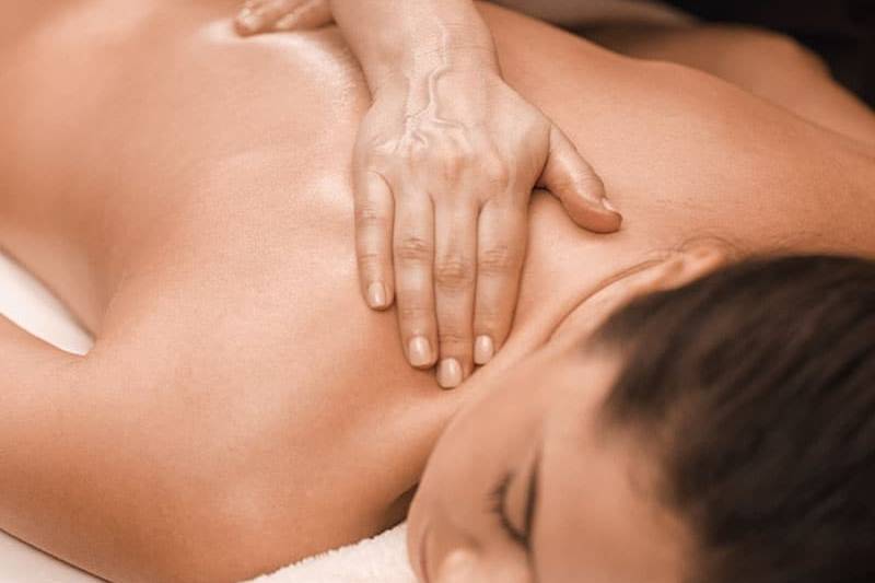 Frau beim Entspannen mit einer Massage am Rücken.