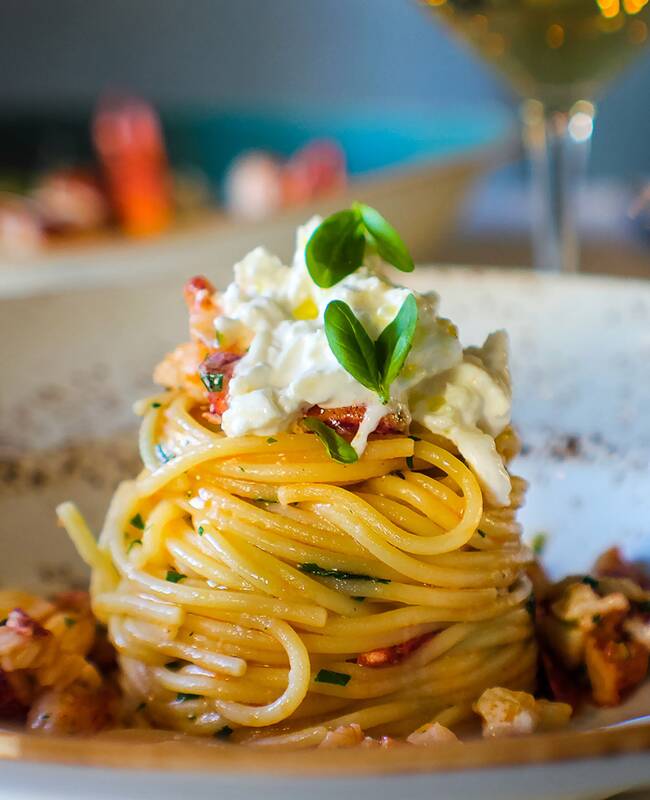 Pasta mit Käse und Meeresfrüchten, drapiert auf einem Teller im Strandhotel auf Rügen.