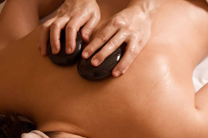 Erhitzte Steine bei einer LaStone-Rückenmassage.