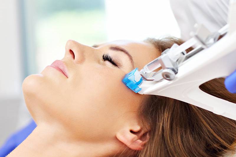Moderne Mesotherapie-Behandlung im Gesicht einer liegenden Frau von ÄsthetikaMed im Arkona Strandhotel auf Rügen.