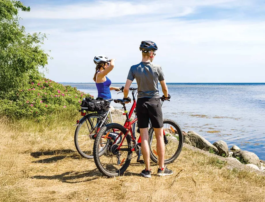 A couple admires the sea view during a cycling trip. Numerous rental options make spontaneous tours easy!