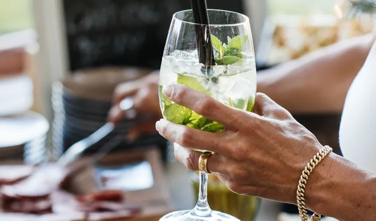 Close-up of a woman holding a cocktail at a banquet in the Arkona Strandhotel in Binz on the island of Rügen.