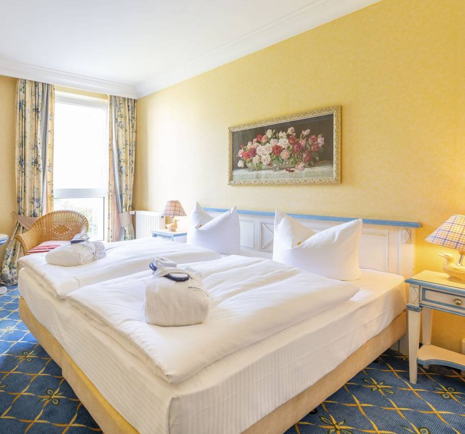 Doppelzimmer im Rugard Thermal Strandhotel mit einem großen Bett, zwei Nachttischen und stimmungsvoller Beleuchtung.