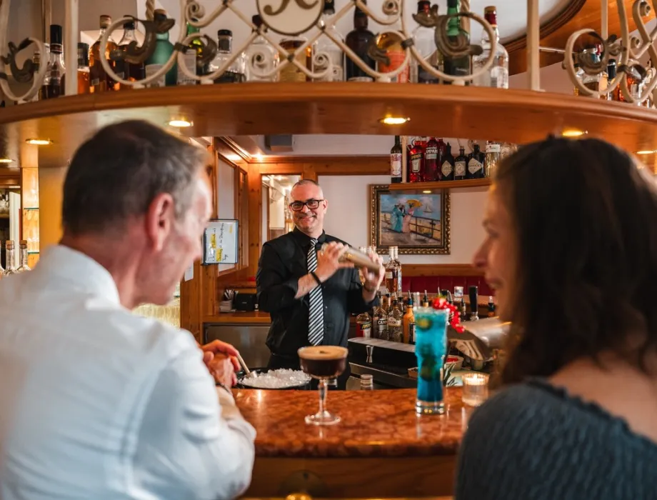 Barkeeper mixt Cocktails für Gäste an der Hotelbar im Rugard Strandhotel in Binz auf Rügen.