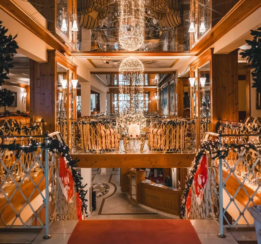 Weihnachtlich geschmückte Hotellobby mit festlicher Beleuchtung, dekorativen Lichterketten und stimmungsvoller Atmosphäre.