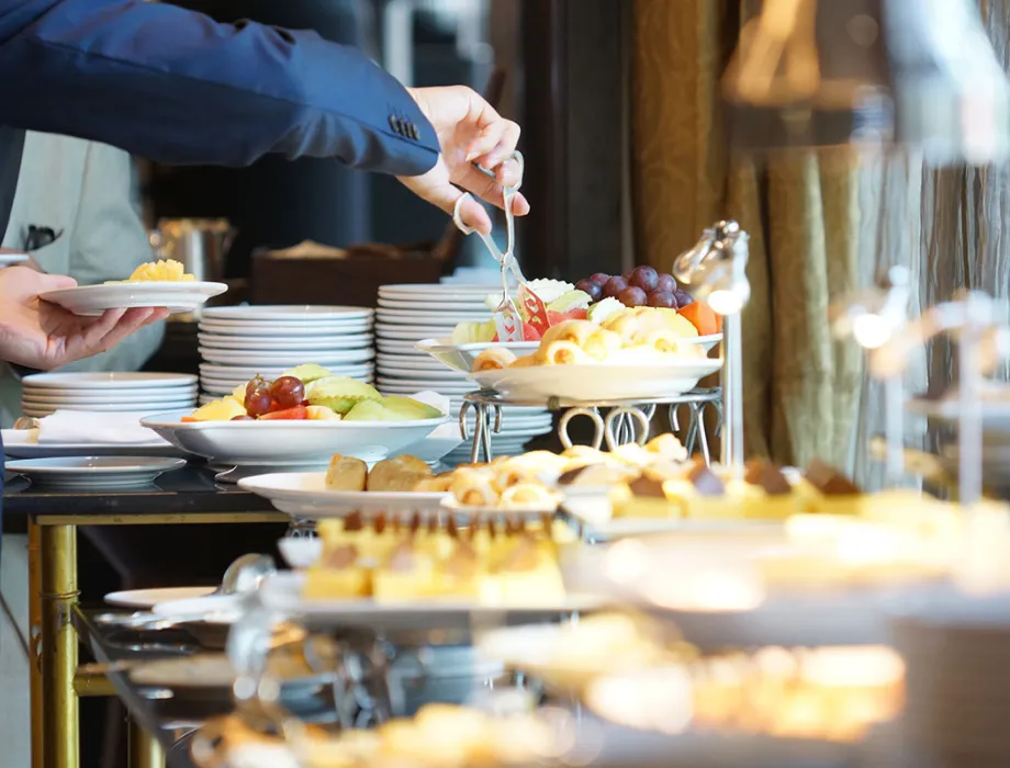 A guest helps himself to the generous breakfast buffet with fruit and pastries.