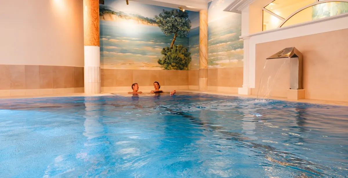 Indoor pool with waterfall in the spa area of Rugard Strandhotel Binz on Rügen Island.