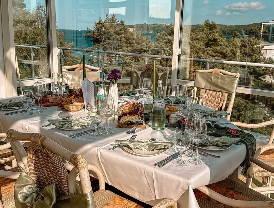 Dekorierter Tisch in einem hellen Restaurantraum in Binz mit Blick auf das Meer und einem Bernsteinwasserfall als Dekoration.