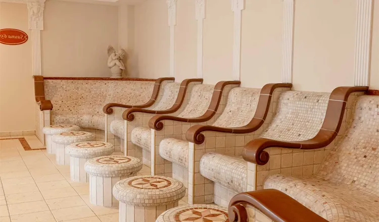 View of heated mosaic loungers with armrests in the quiet tepidarium of the Rugard Thermal Strandhotel.