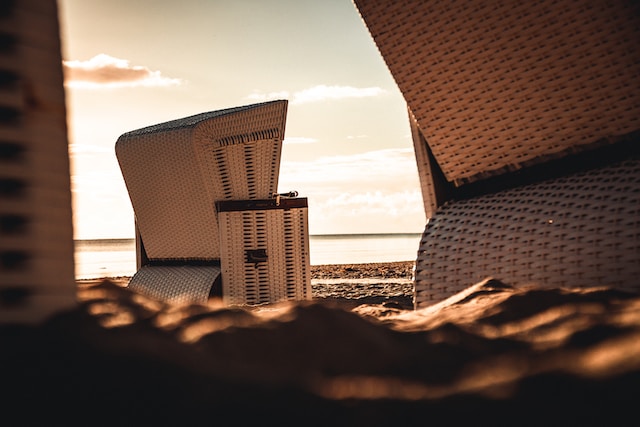 Detailaufnahme von Strandkörben beim Sonnenuntergang am Strand.