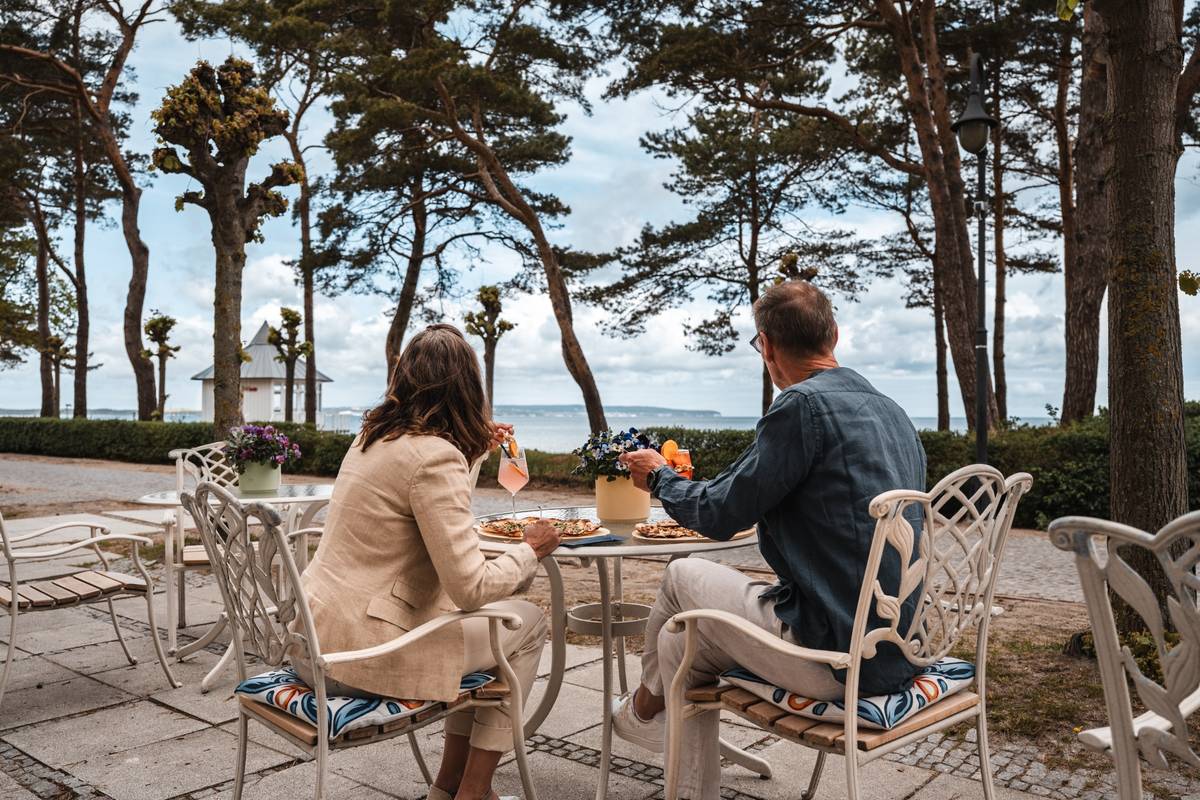 Three people, with only their hands visible, are toasting with cocktails.