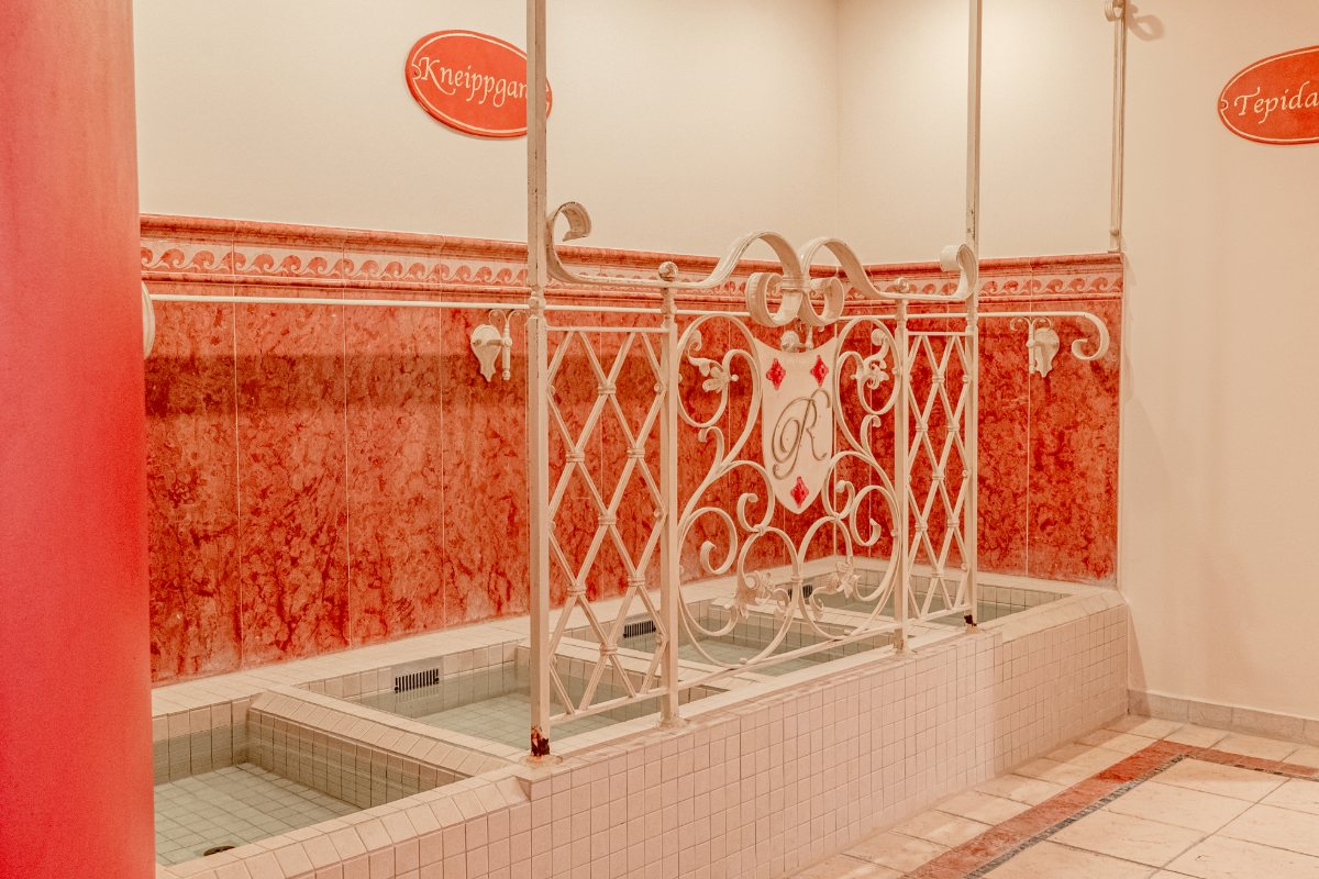 Detailaufnahme eines Kneippgangs mit eingelassenen Becken und dekorativem Gusseisengeländer oim Rugard Thermal Strandhotel.