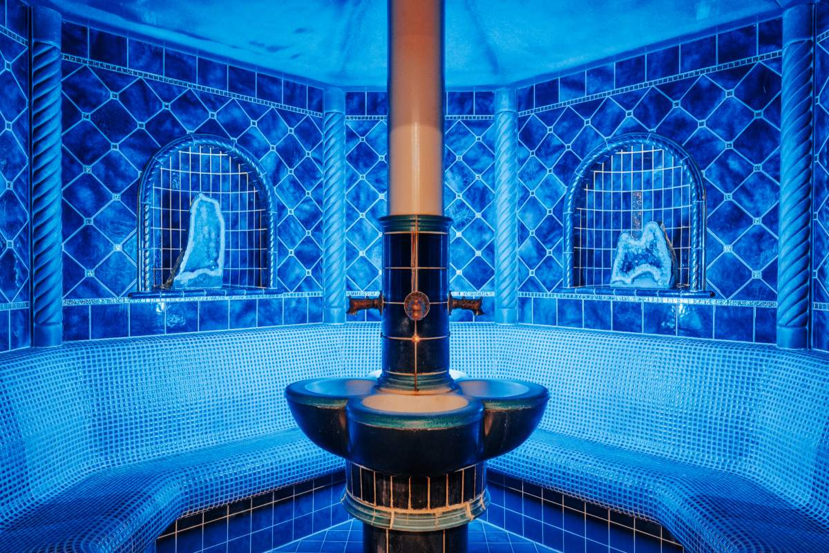 Innenraum der blauen Edelsteingrotte mit runder Sitzbank und Dampfquelle im Rugard Thermal Strandhotel.