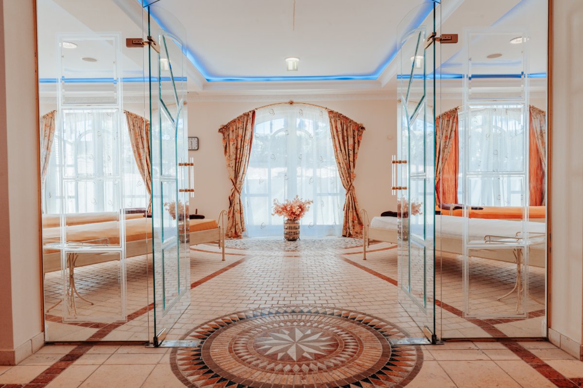 Eleganter Ruhebereich mit hellen Liegen, Glastüren und Tageslicht im Spa des Rugard Thermal Strandhotels.