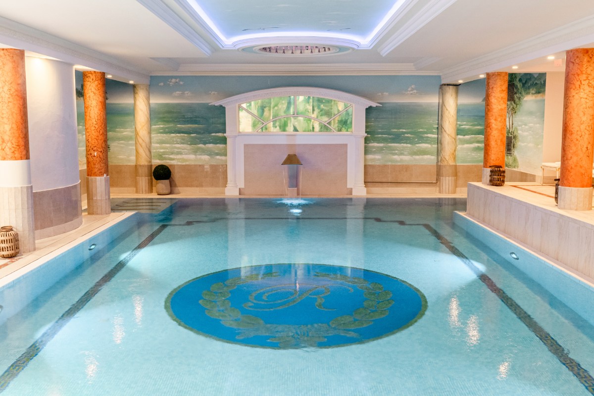 Großzügiger Pool mit mediterranem Wandbild und Mosaikornament im Wellnessbereich des Rugard Strandhotels