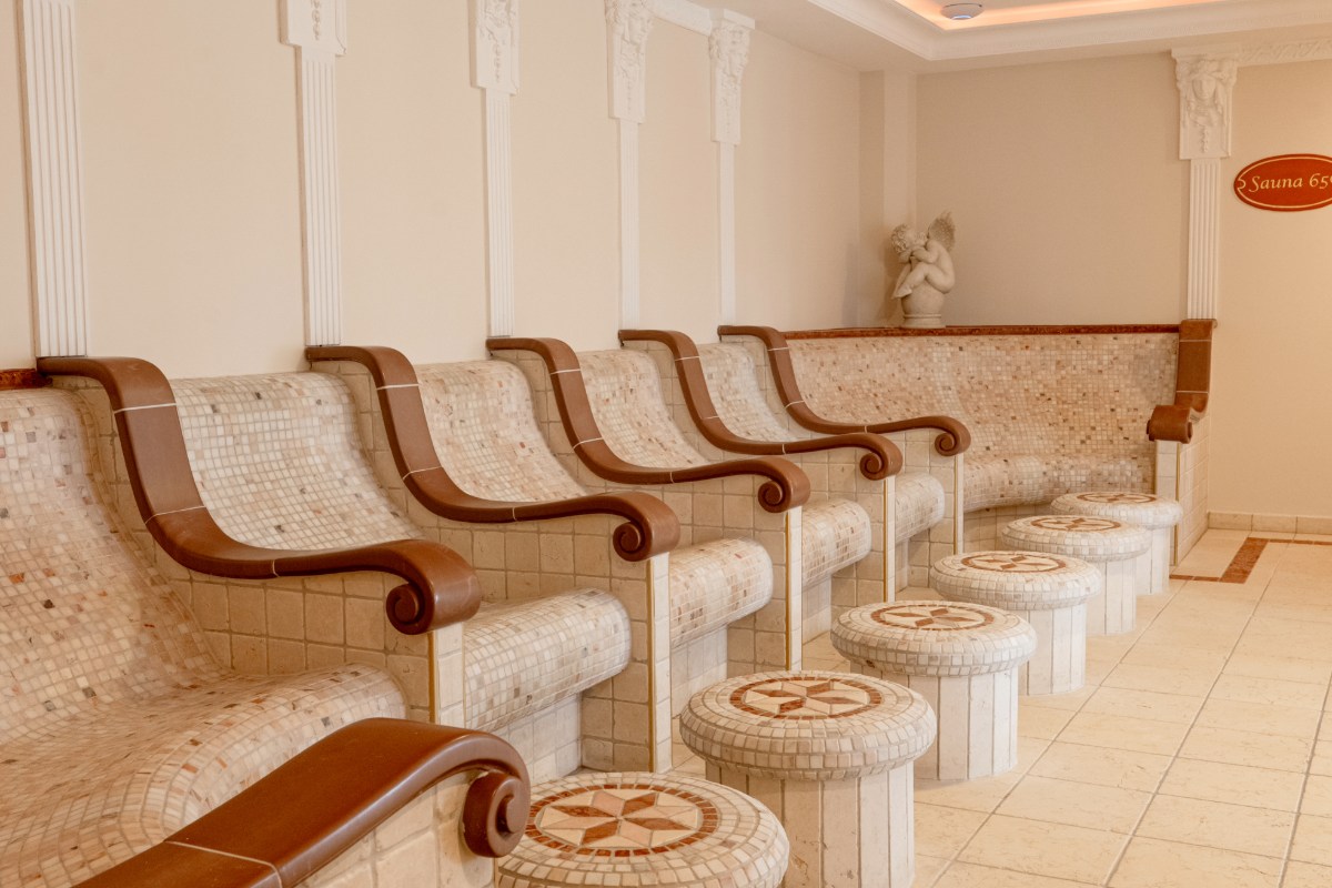 Eleganter Entspannungsraum im Tepidarium mit beheizten Steinliegen im mediterranen Stil des Rugard Strandhotels.