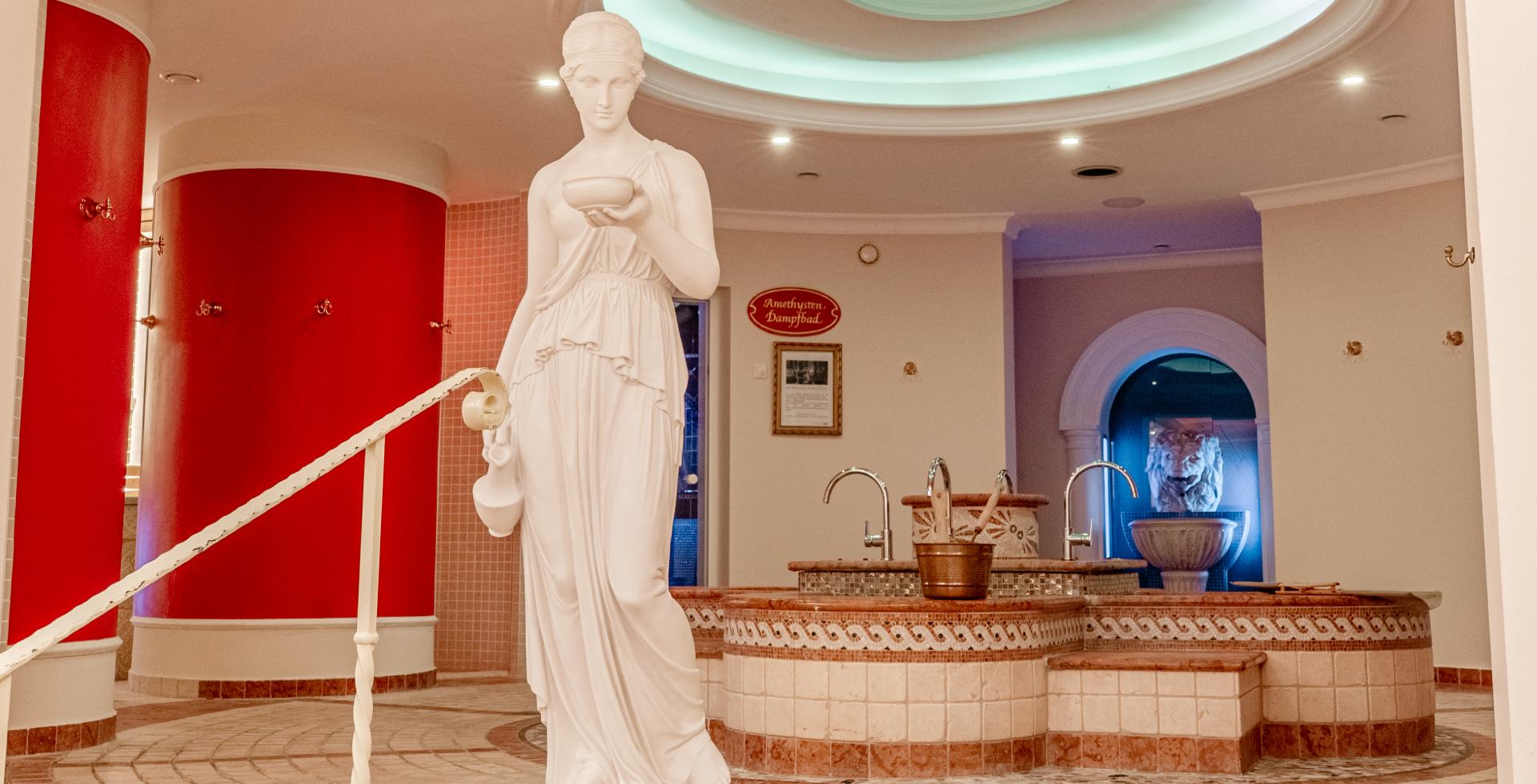 Innenraum mit antiker Statue, Waschbecken und Eislöwen im Spabereich des Rugard Thermal Strandhotels auf Rügen.
