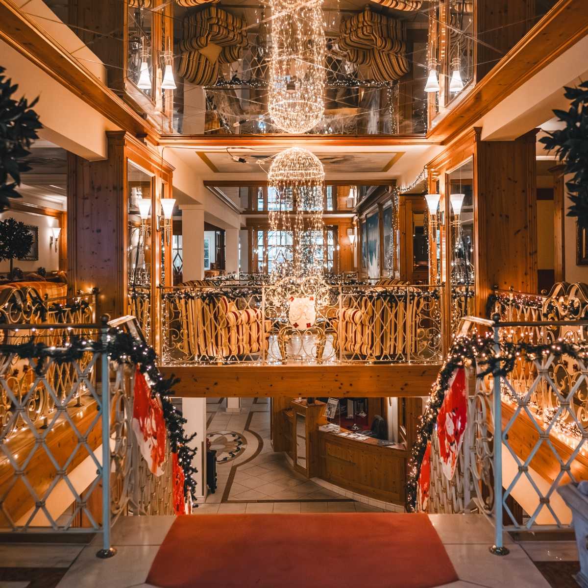 Weihnachtlich geschmückte Hotellobby mit festlicher Beleuchtung, dekorativen Lichterketten und stimmungsvoller Atmosphäre.